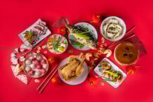 Whole fish served for Lunar New Year, symbolising abundance and prosperity in a festive, elegant setting.