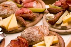 Rustic Tyrolean aperitivo spread with speck, mountain cheeses, Schüttelbrot, and pickled vegetables, perfect for enjoying Northern Italian snacks and drinks in the Dolomites.