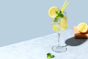 Hugo Spritz cocktail in a wine glass with mint and lime, a refreshing Northern Italian aperitivo drink from South Tyrol.